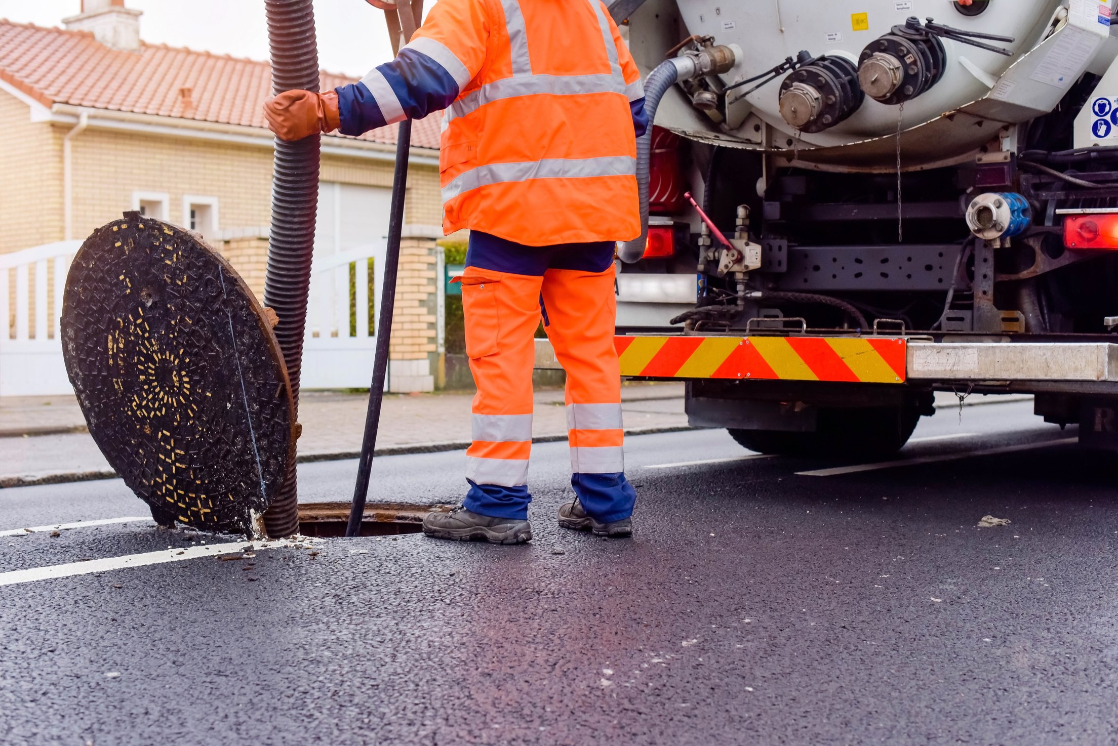 workers cleaning and maintaining the sewers on the roads